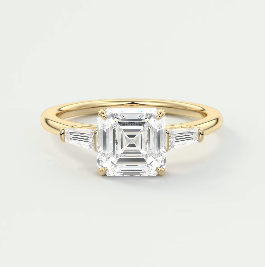 18k yellow gold engagement ring with an asscher-cut diamond and baguette side stones.