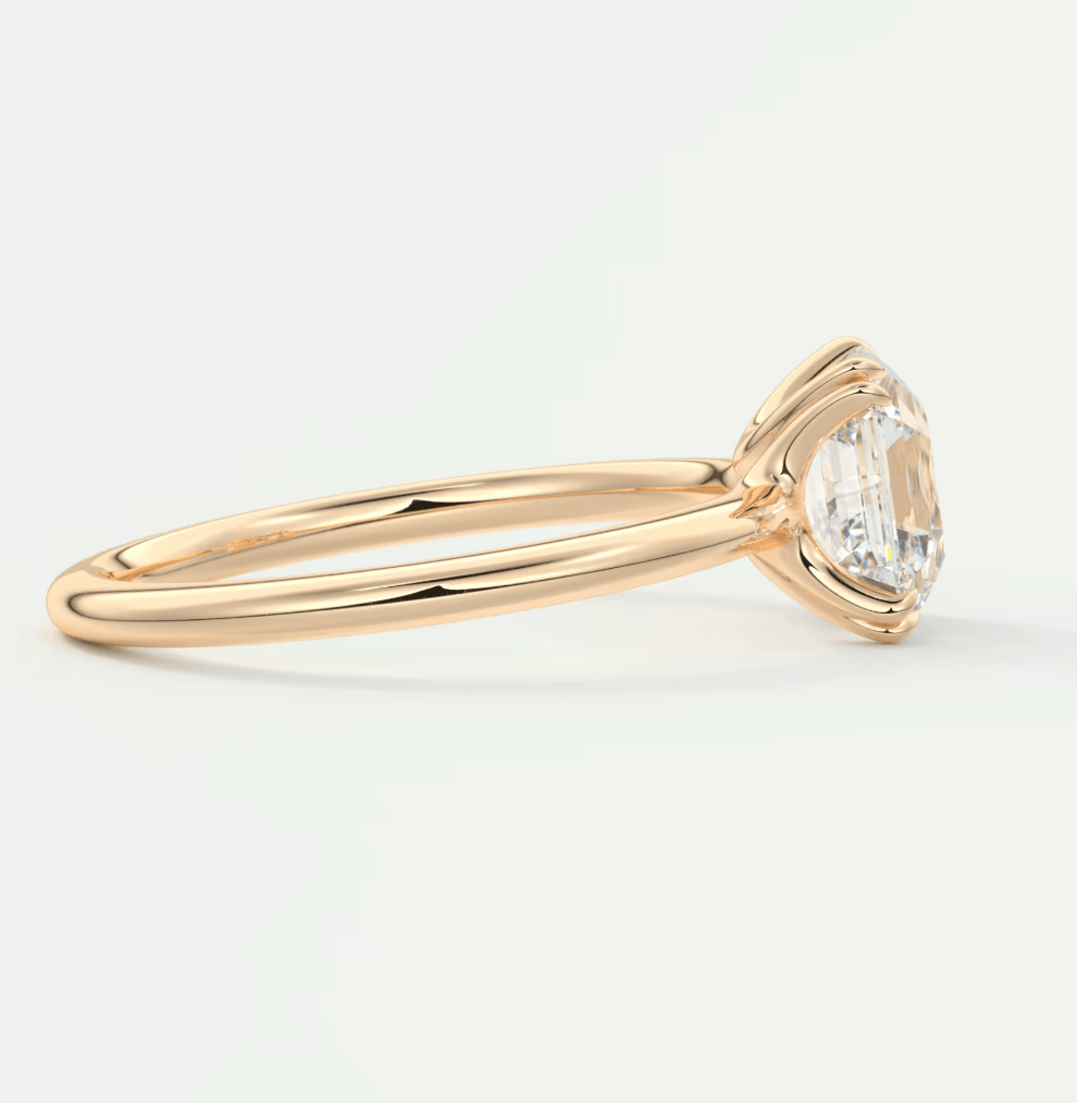 18-karat gold engagement ring with a round diamond, featuring a classic bezel setting.