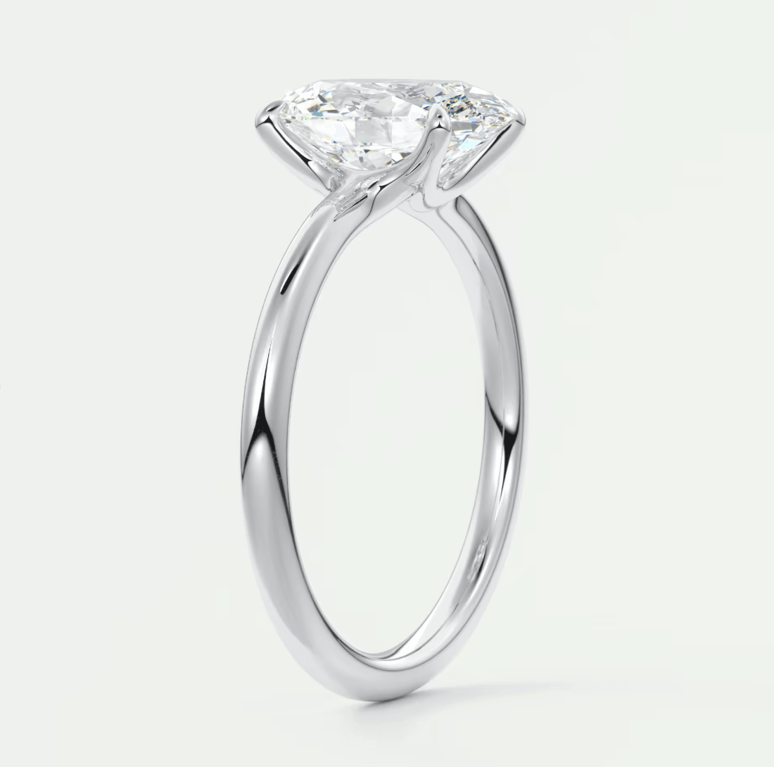 18-karat white gold solitaire engagement ring with a cushion-cut diamond.