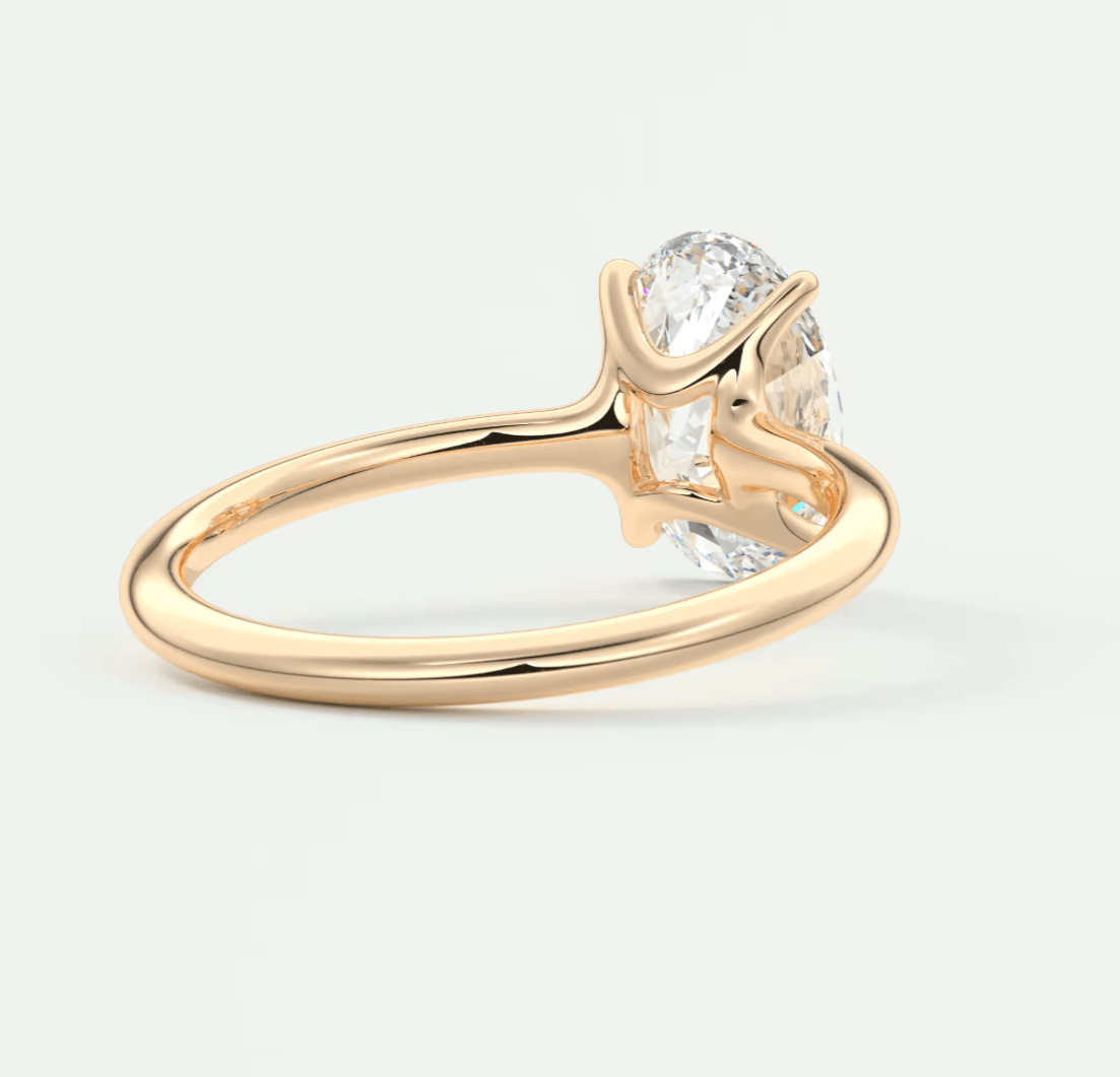 18-karat gold solitaire diamond engagement ring with a cushion-cut gemstone.