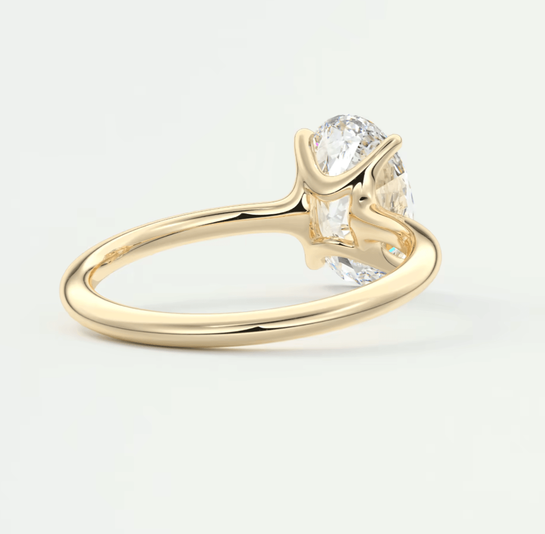 18-karat yellow gold engagement ring with a round diamond center stone and two smaller diamonds on either side.
