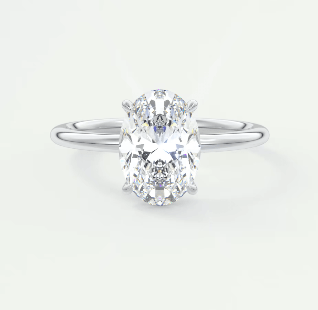 18-karat white gold oval diamond engagement ring with a princess cut center stone and two side diamonds.