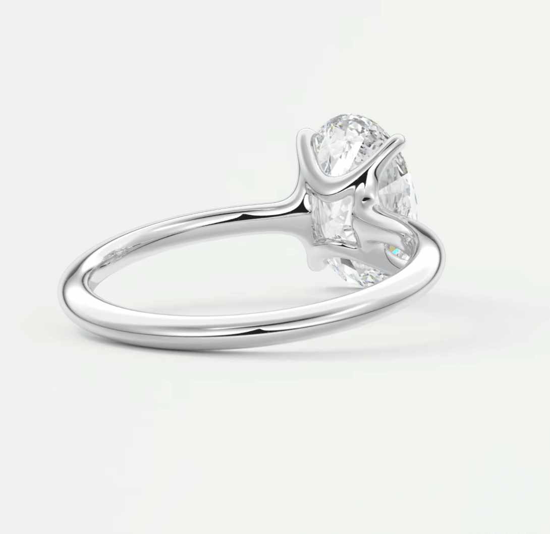 18k white gold diamond engagement ring with a pear-shaped center stone and two smaller stones on either side.