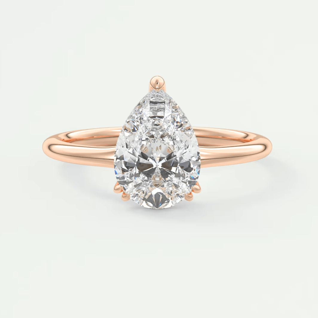 Rose gold pear-shaped diamond engagement ring with a solitaire setting.