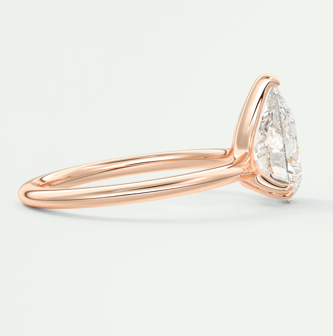 18k rose gold marquise diamond engagement ring with a classic solitaire design.