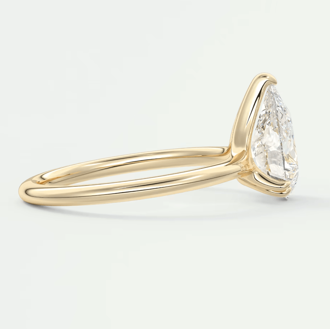 18-karat yellow gold pear-shaped diamond engagement ring.