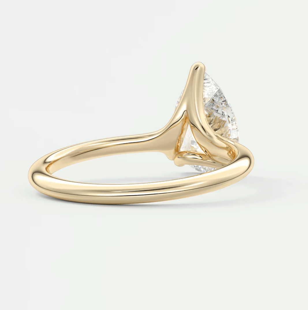 18k gold diamond engagement ring with a pear-shaped stone.