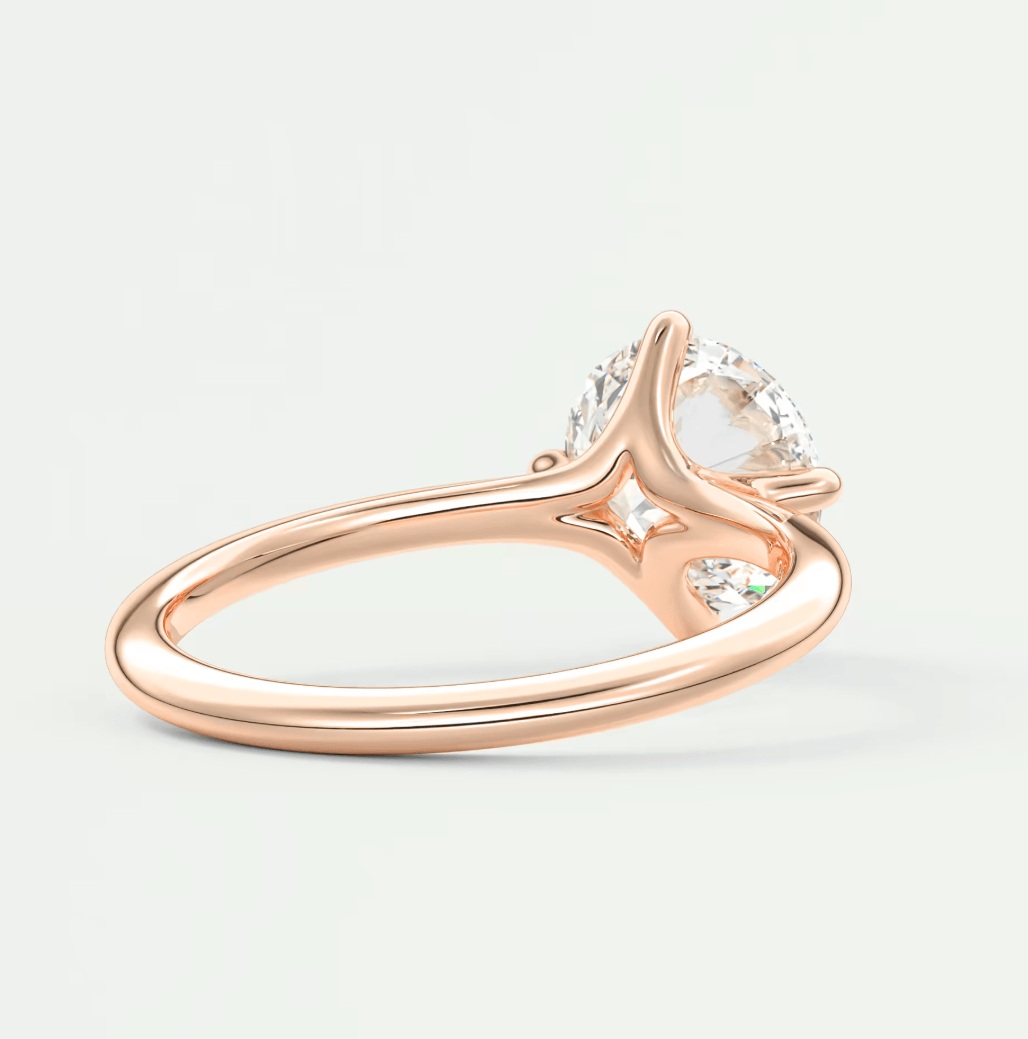 Rose gold diamond engagement ring with a marquise-cut center stone and small side diamonds.