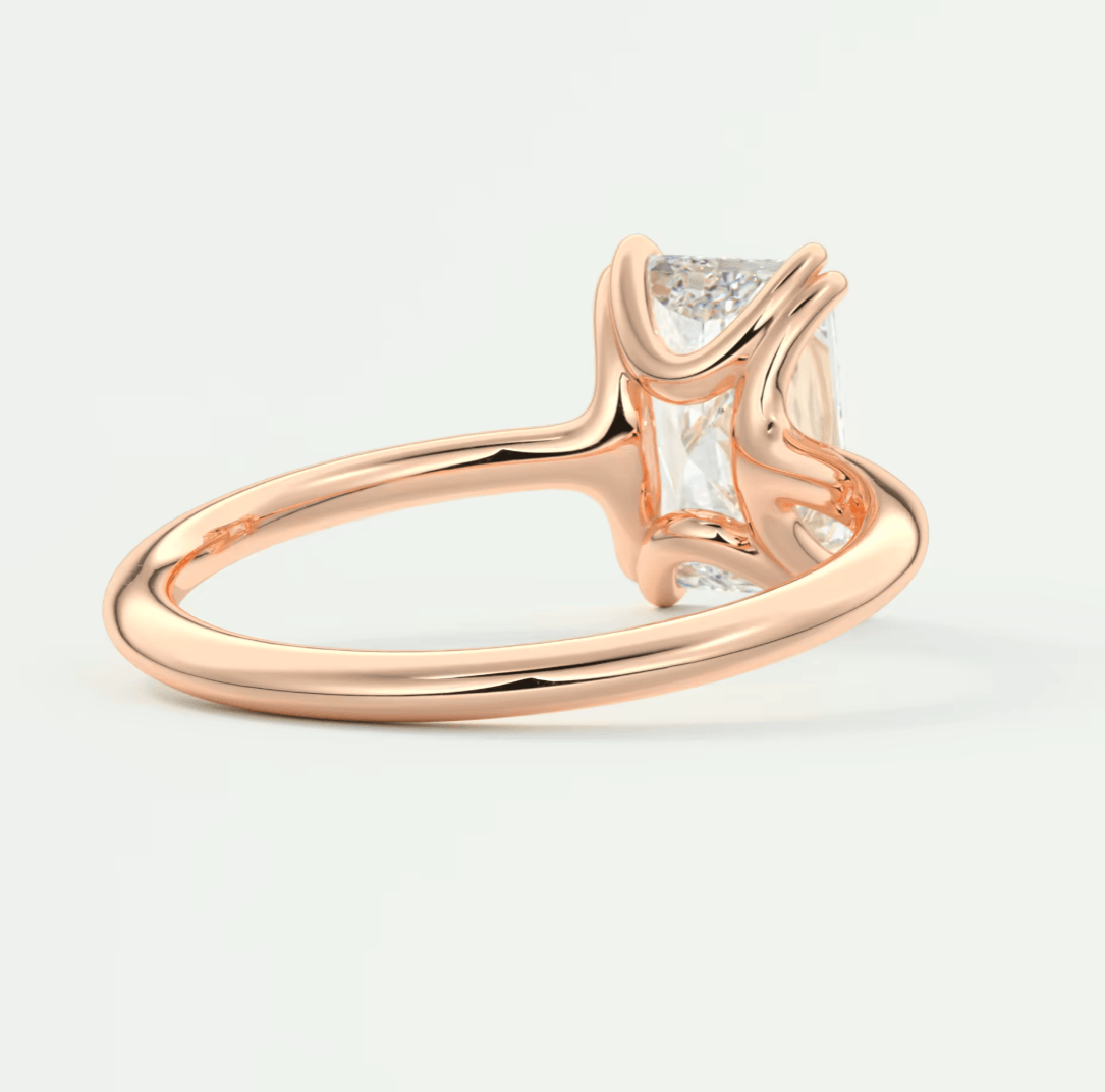 Rose gold diamond engagement ring with a baguette-cut center stone and small side diamonds.
