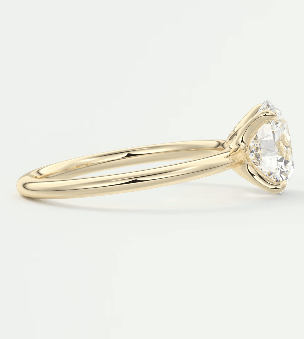 18-karat yellow gold engagement ring with a round diamond center stone and small accent diamonds on the band.