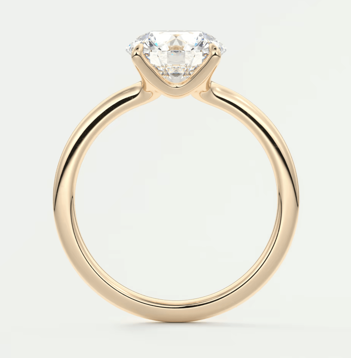 18-karat gold solitaire diamond engagement ring with a round-cut gemstone.