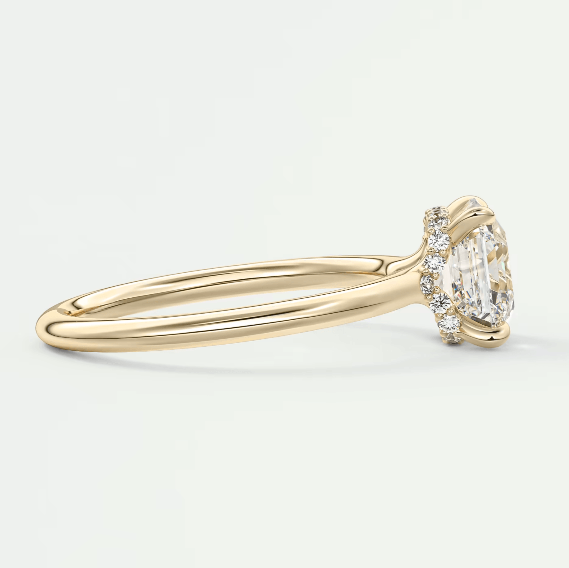 18k yellow gold diamond engagement ring with a cushion-cut center stone and small round diamonds on the band.