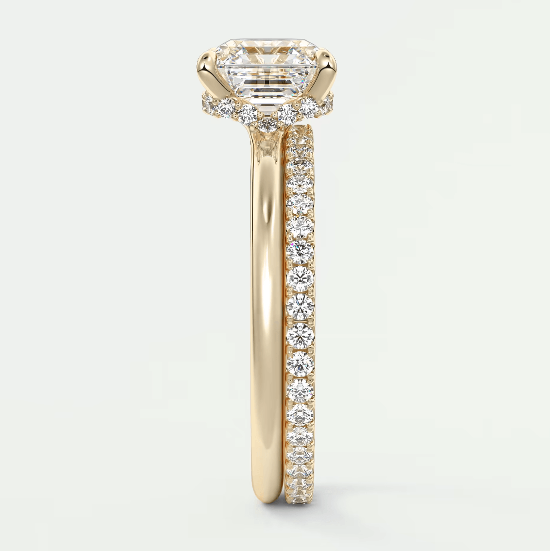 18k yellow gold engagement ring with emerald cut diamond and pave set diamonds on band.