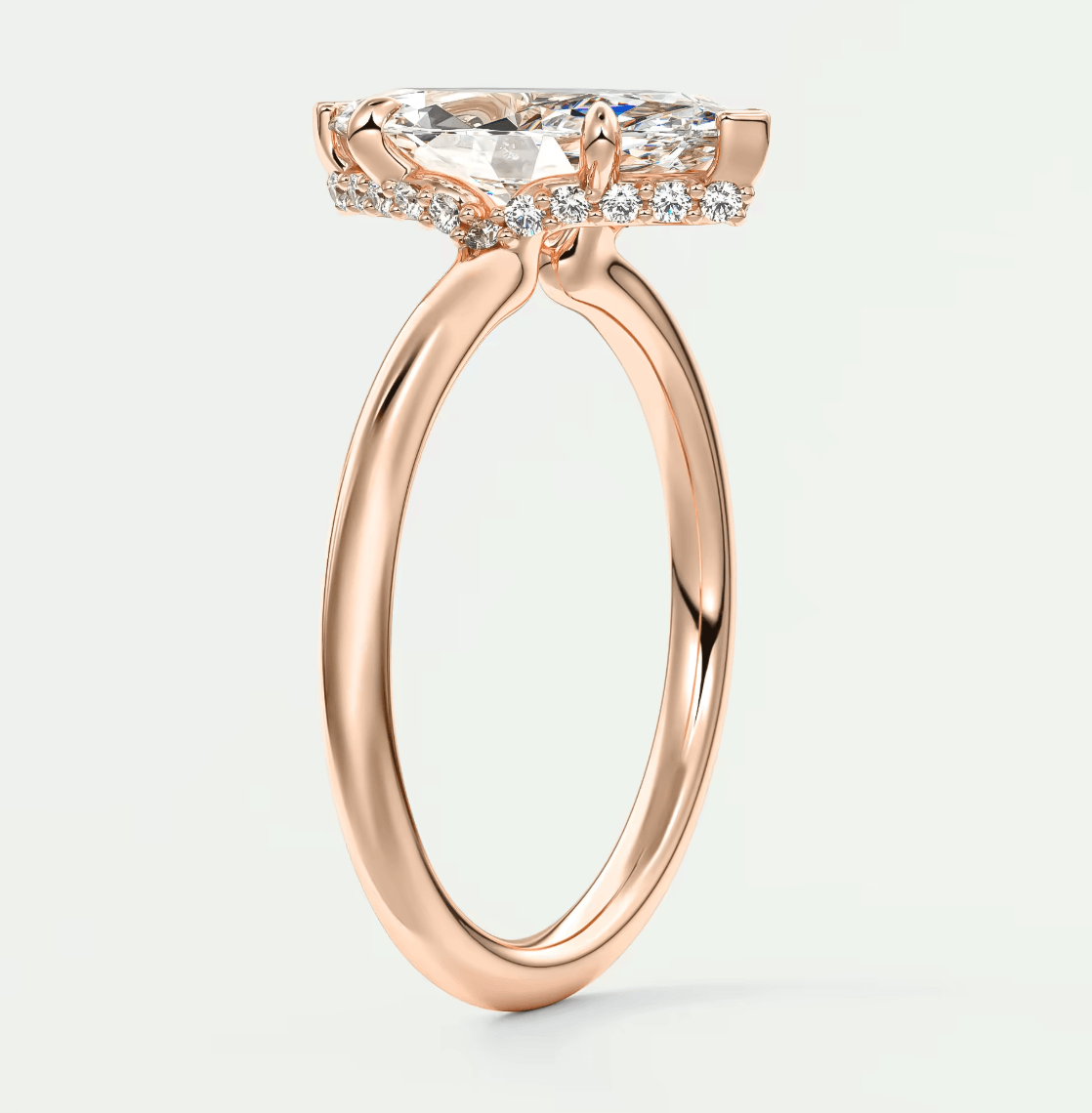 18-karat rose gold engagement ring with a cushion-cut diamond and pavé halo.