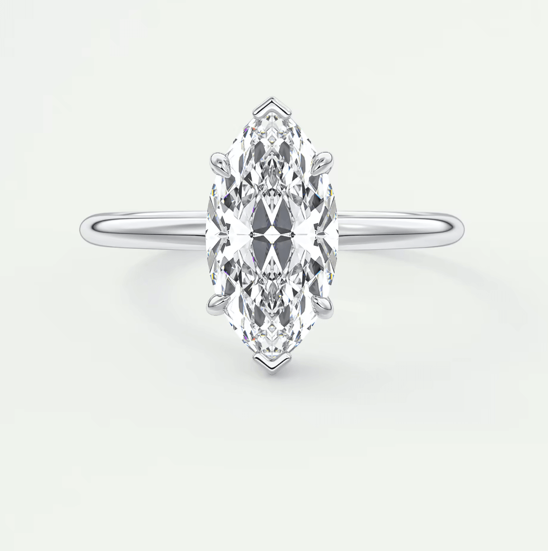 Marquise-cut diamond engagement ring with white gold band, featuring a central stone and intricate detailing.