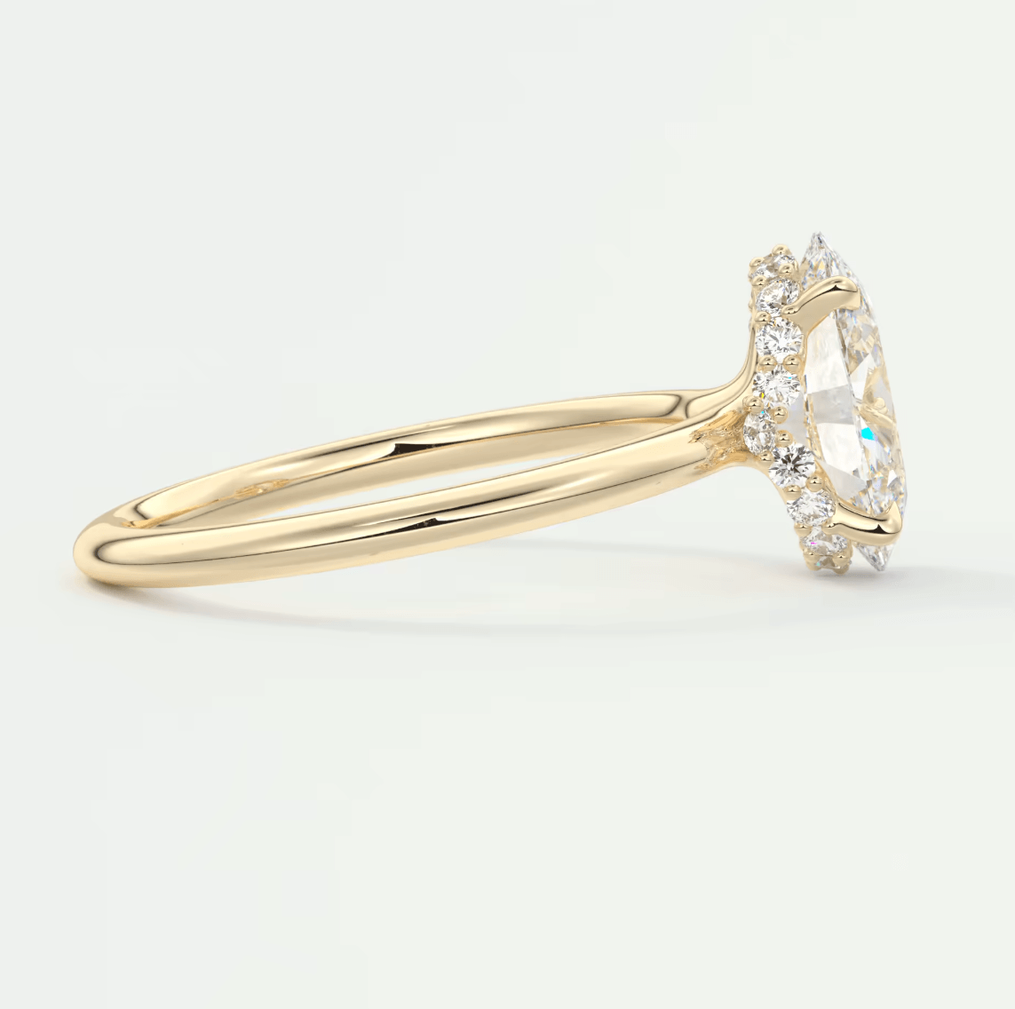 18-karat yellow gold engagement ring with a marquise-cut diamond center stone and halo of smaller diamonds.