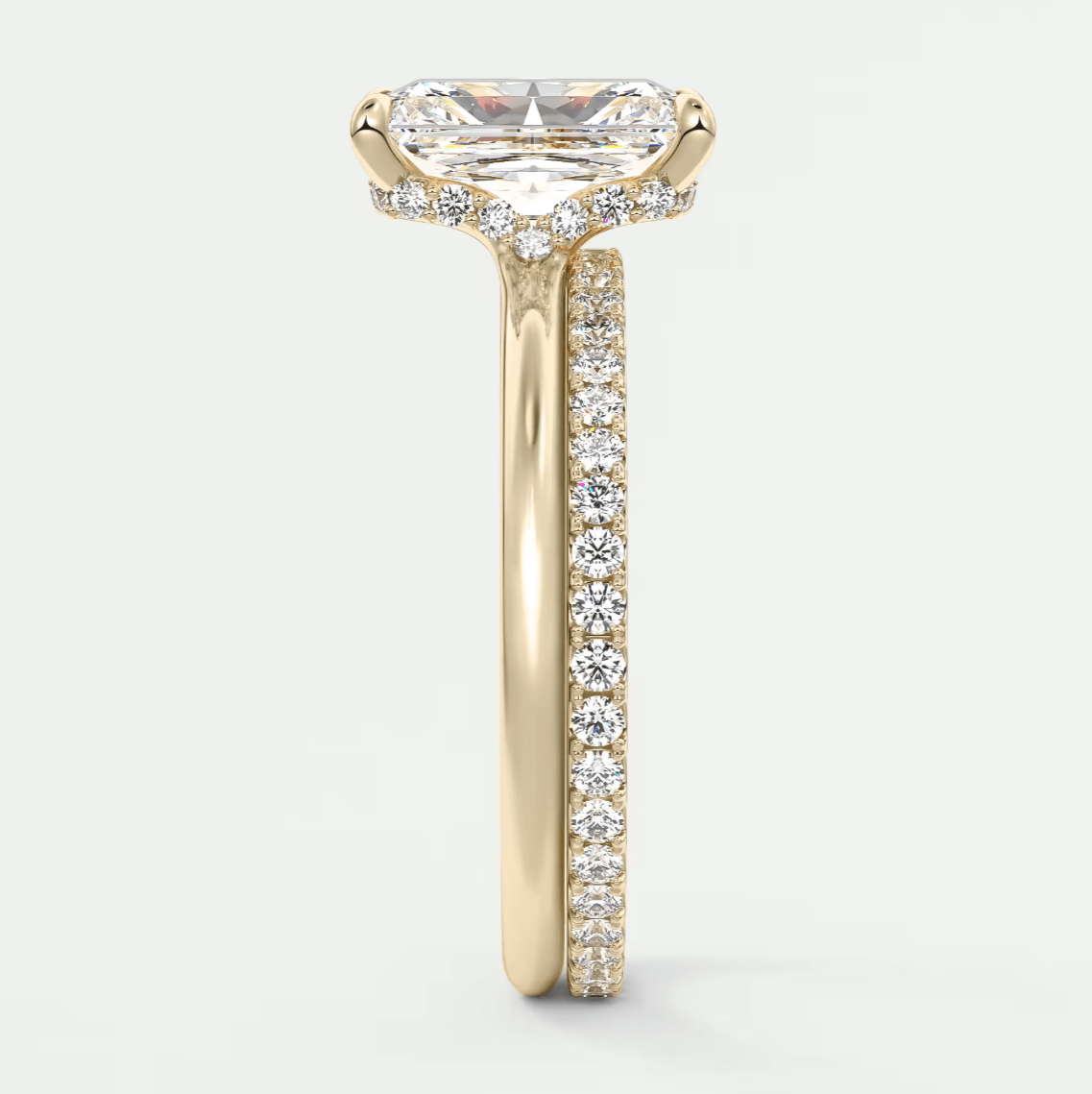 18k yellow gold engagement ring with a princess cut diamond and pavé side stones.