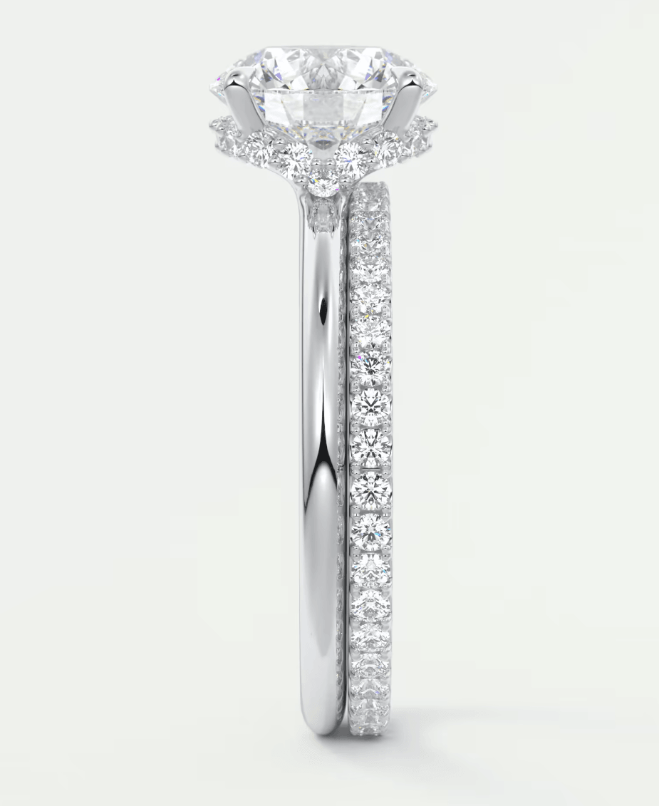 18-karat white gold engagement ring with a round diamond center stone and pave-set diamonds on the band.