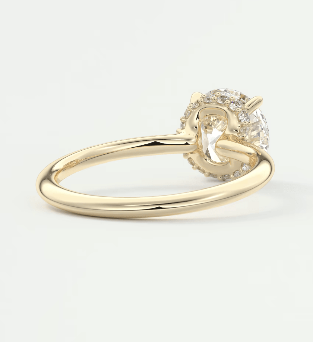18k yellow gold engagement ring with a round diamond center and halo of smaller diamonds.