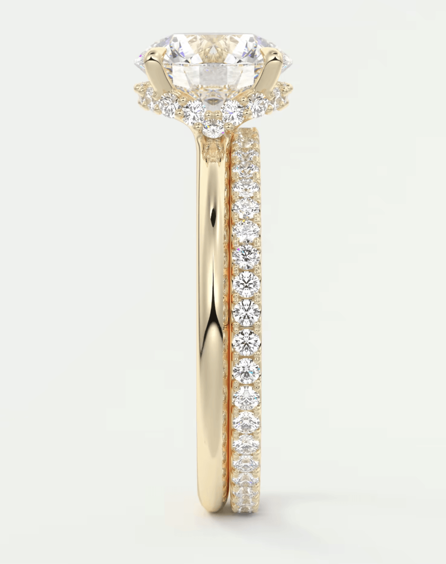 18k yellow gold engagement ring with a round diamond center and pave set diamonds on the band.