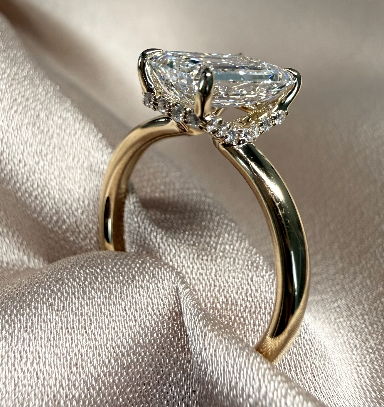 Gold ring with a large diamond on a textured fabric background