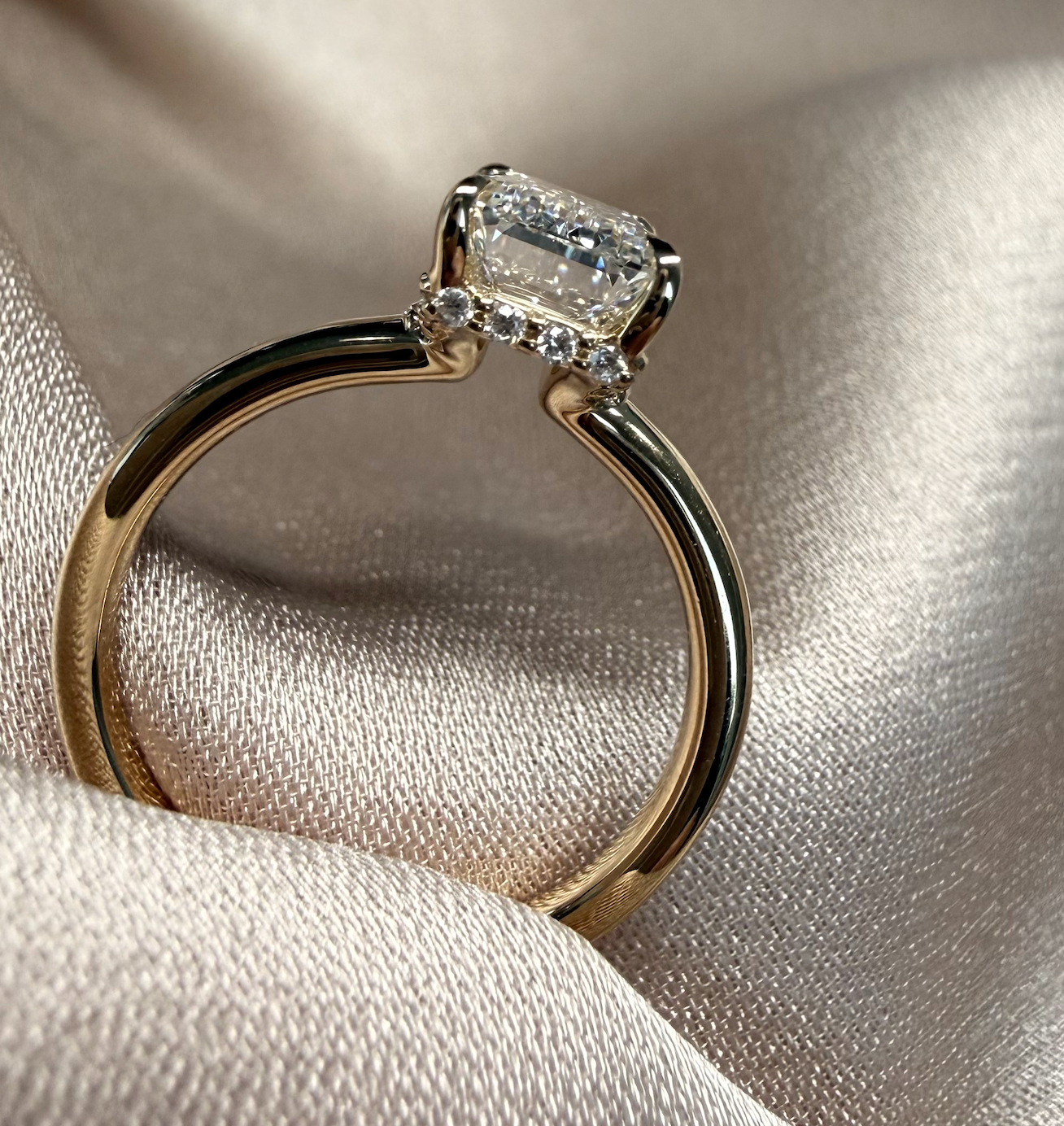 Gold ring with a diamond on a beige fabric background