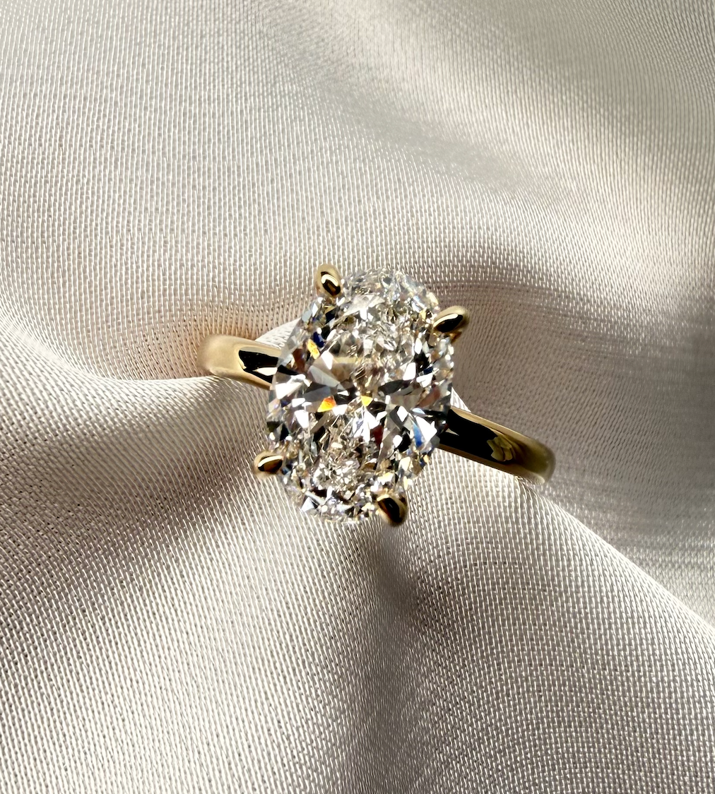 Diamond ring on a soft, light-colored fabric background