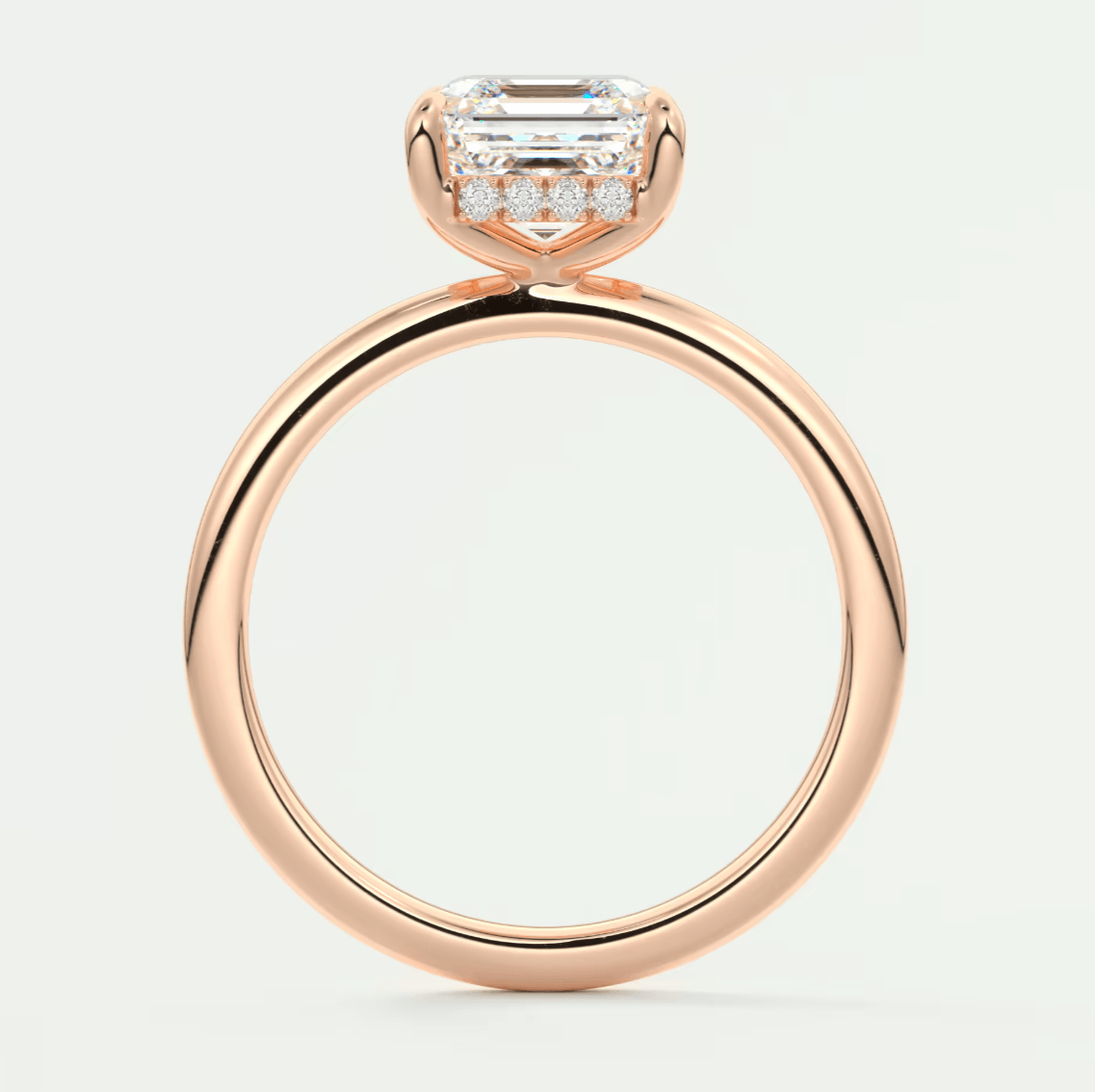 18k rose gold engagement ring with emerald-cut diamond and pavé side stones.
