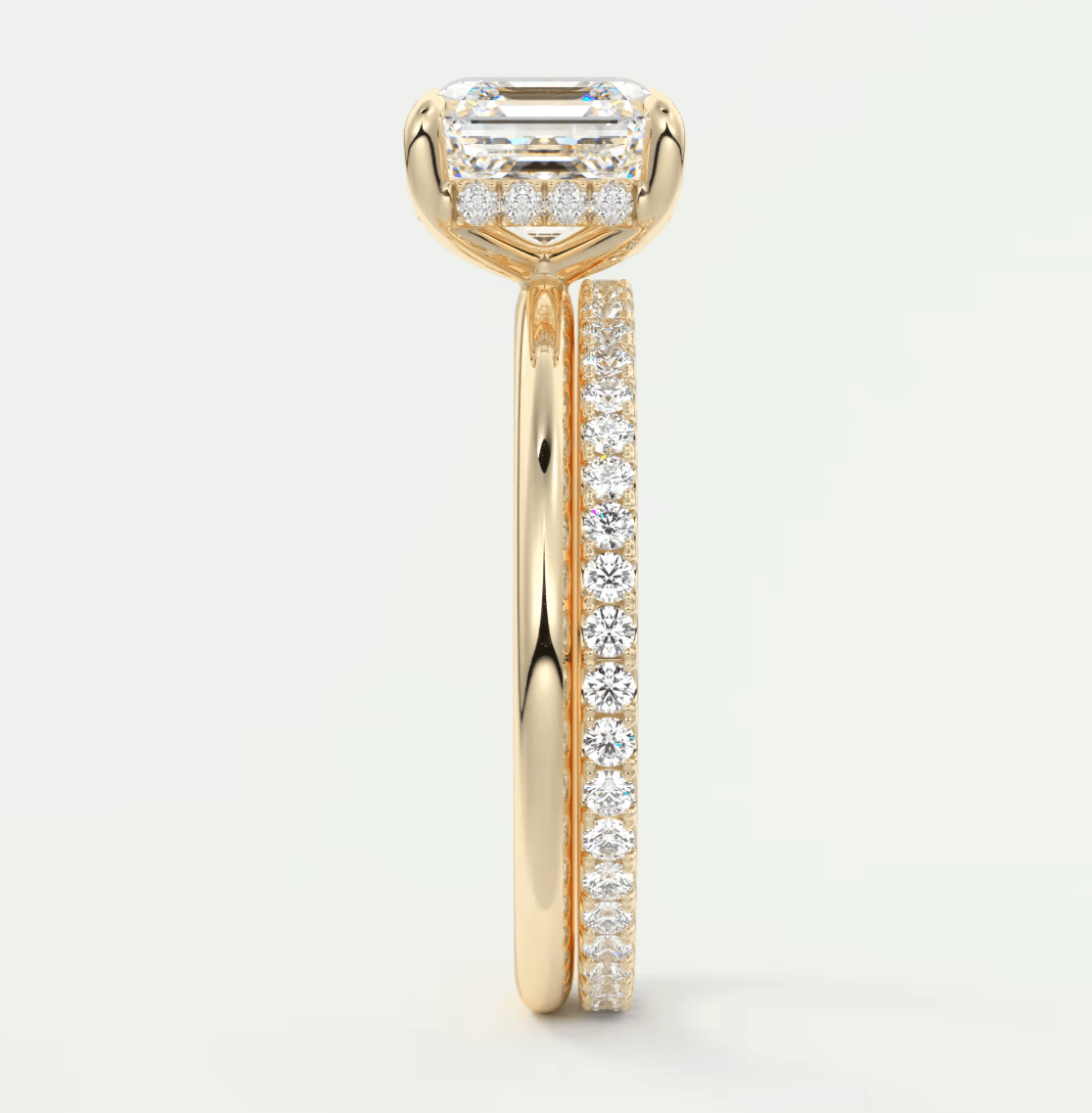 18k yellow gold engagement ring with emerald cut diamond and pave set diamonds on band.