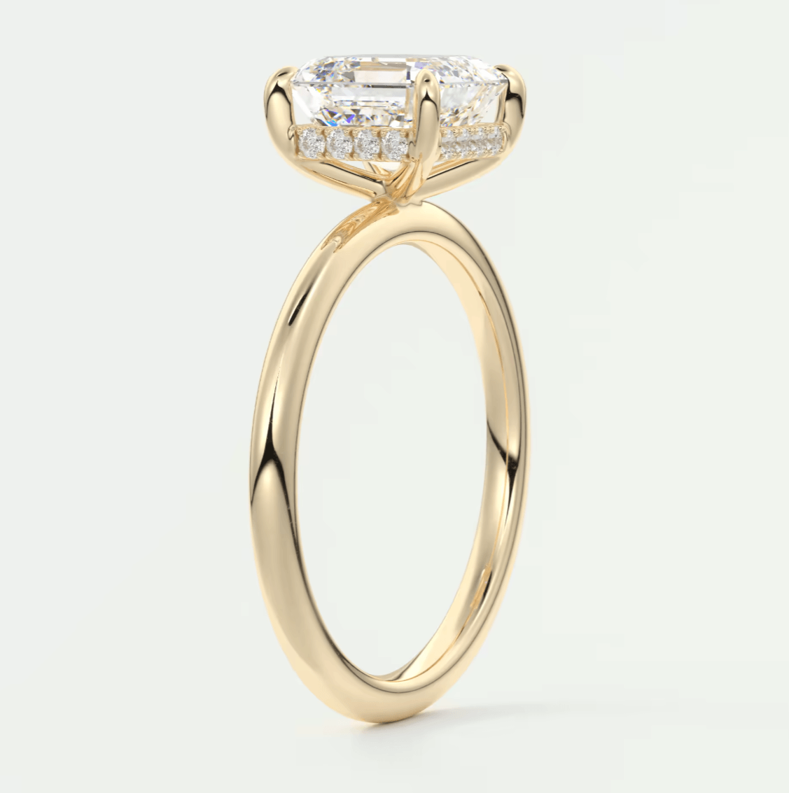 18-karat yellow gold engagement ring with a princess-cut diamond center stone and halo of smaller diamonds.