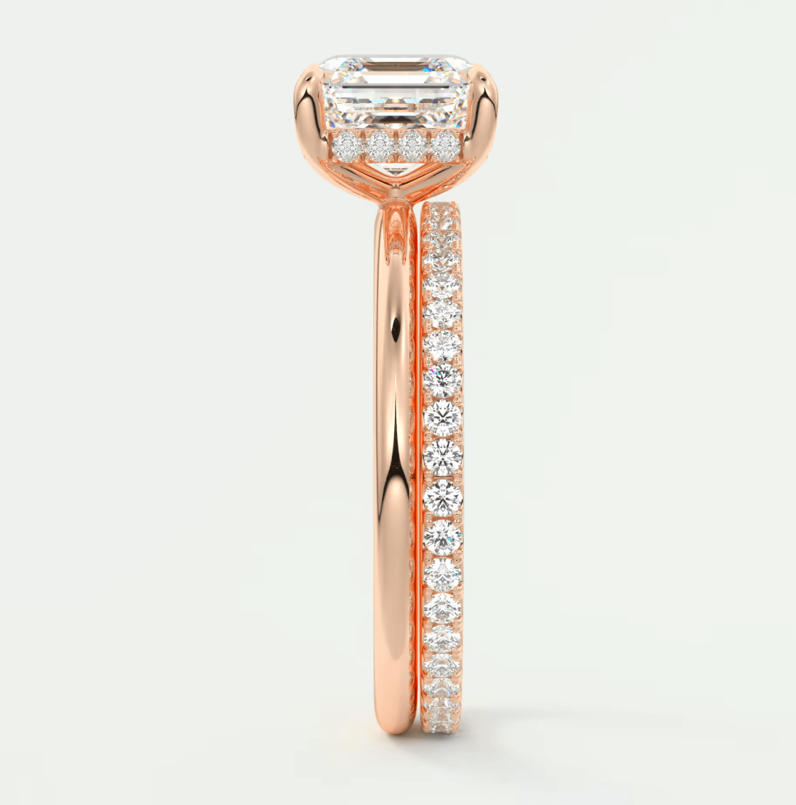 18k rose gold diamond engagement ring with an emerald cut center stone and a matching band.