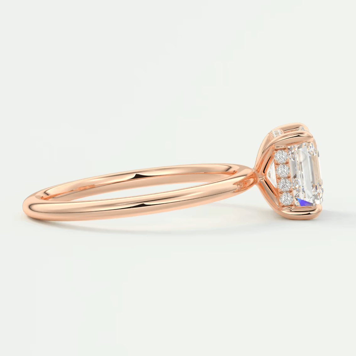 18k rose gold emerald cut diamond engagement ring with a halo of smaller diamonds.