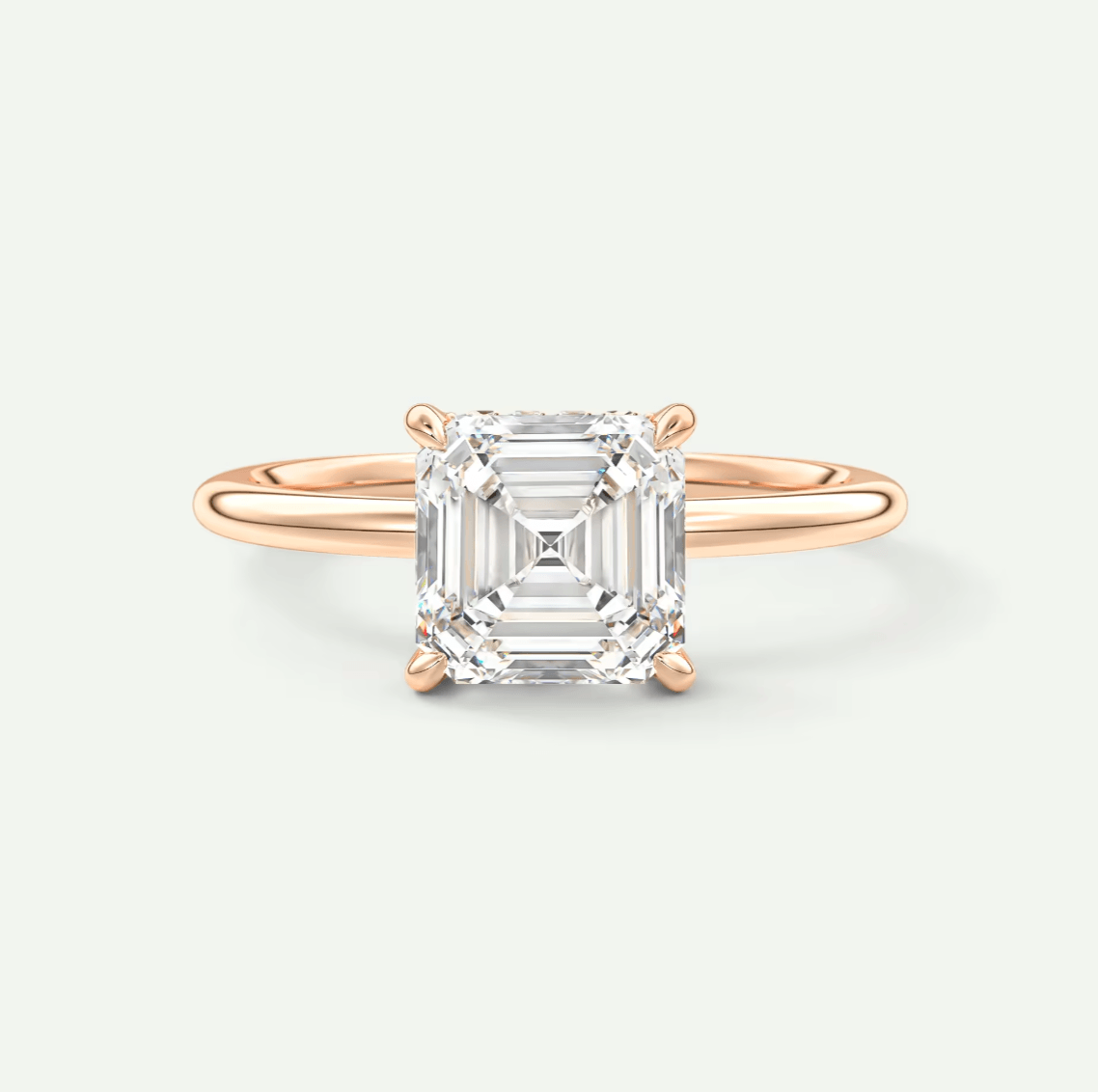 18-karat rose gold engagement ring with a cushion-cut diamond.