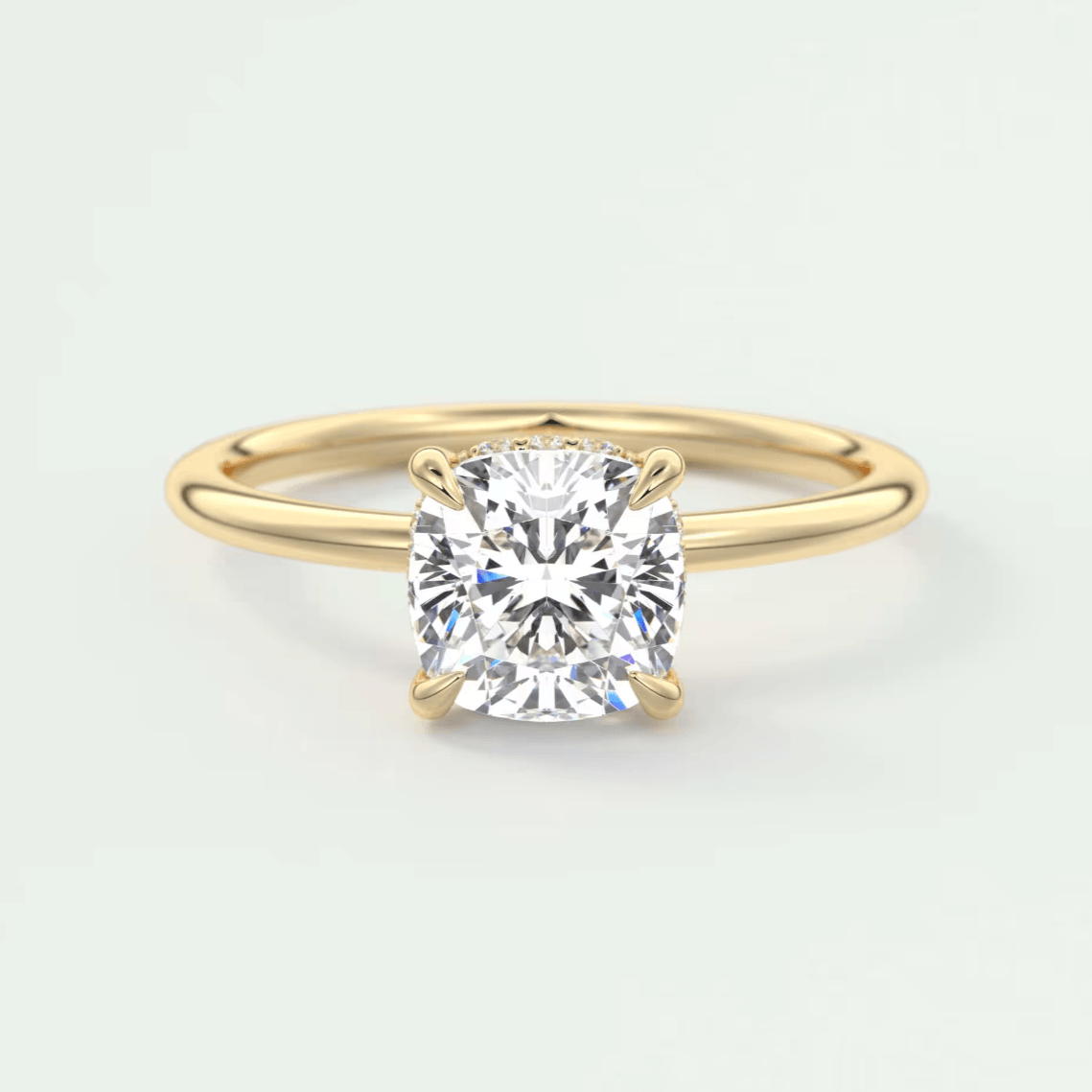 18-karat gold engagement ring with a cushion-cut diamond.