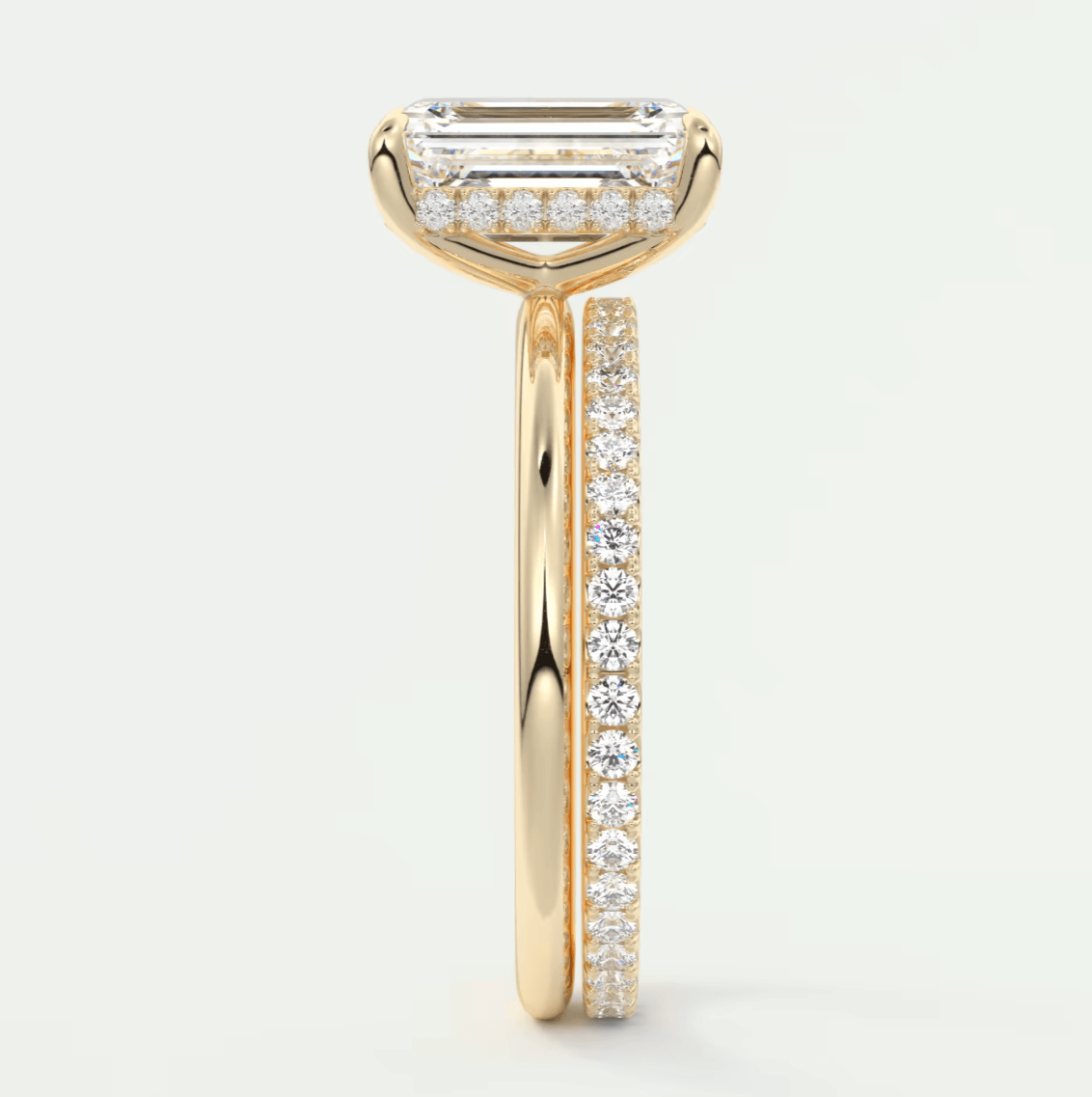 18-karat yellow gold engagement ring with a baguette-cut diamond center and pavé-set diamonds on the band.