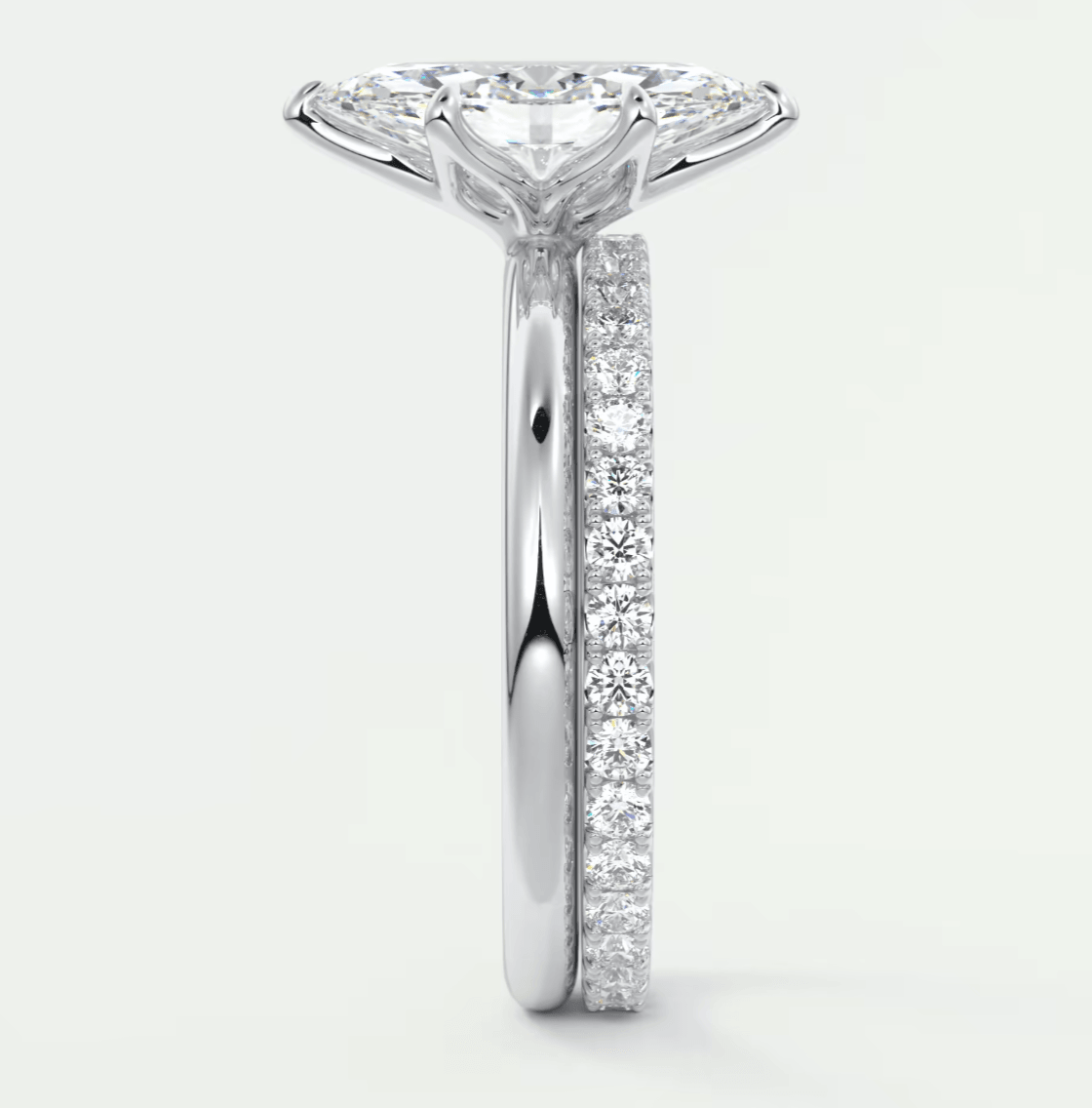 18-karat white gold diamond engagement ring with a princess-cut center stone and pavé set diamonds on the band.