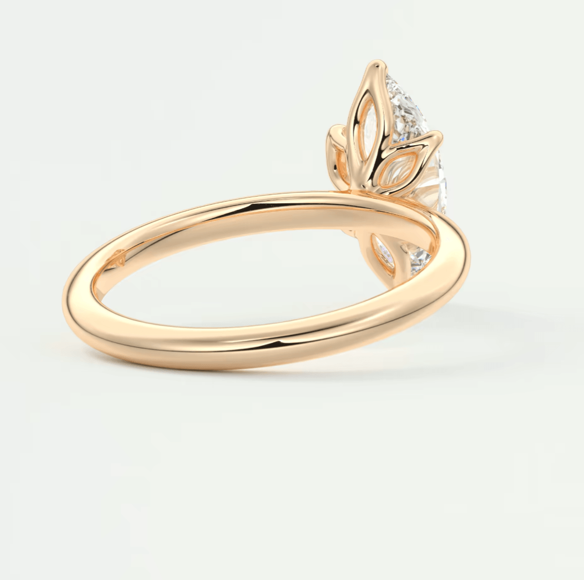 18-karat rose gold engagement ring with a diamond and leaf design.
