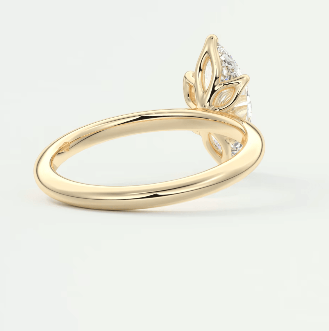 18k yellow gold engagement ring with a diamond leaf design.