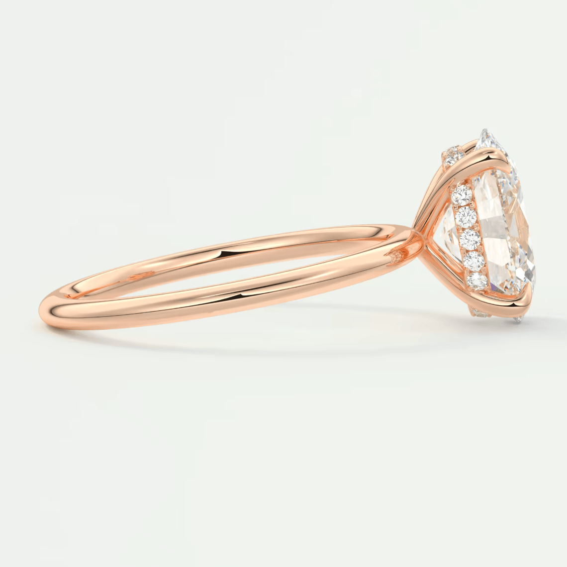 18k rose gold engagement ring with marquise-cut diamond and halo of smaller diamonds.