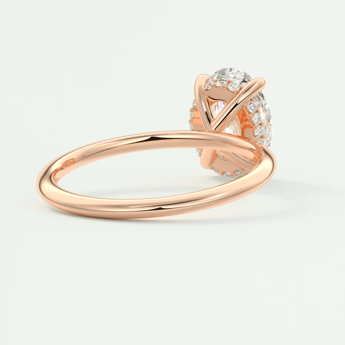18-karat rose gold engagement ring with a round diamond and small side diamonds.