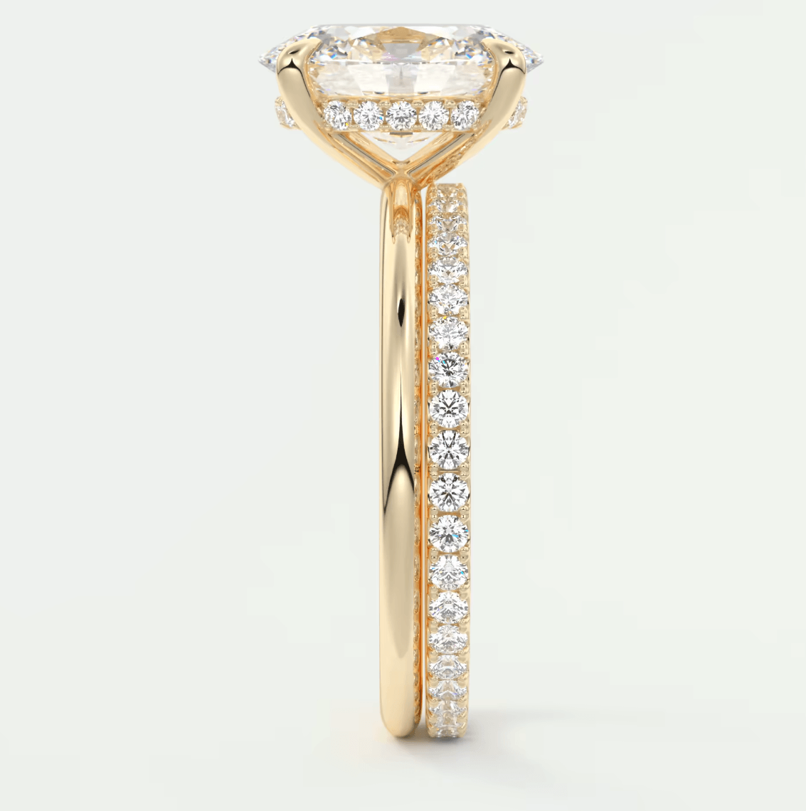18-karat yellow gold engagement ring with a cushion-cut diamond and pavé-set diamonds on the band.