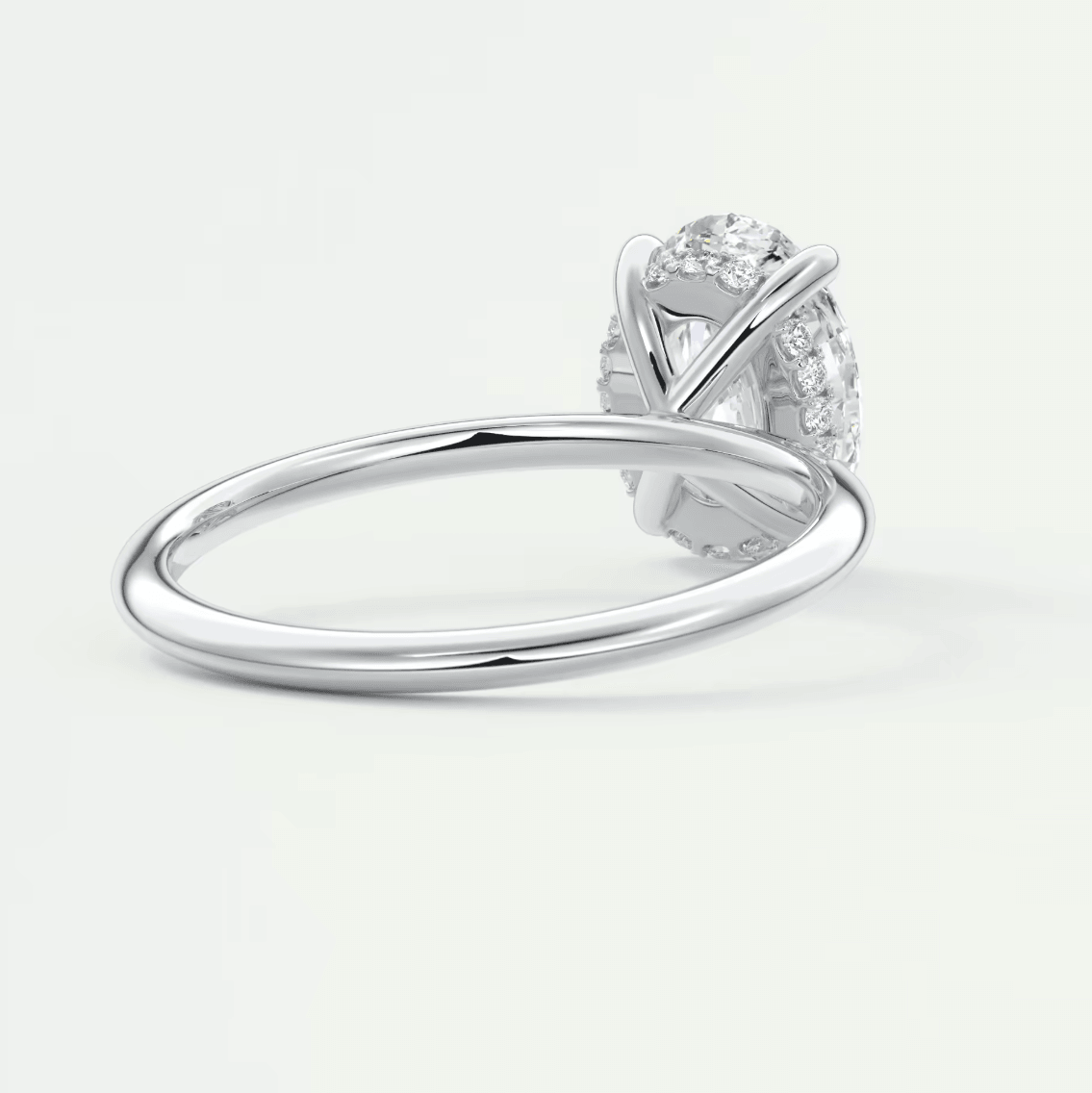 18k white gold diamond engagement ring with a round-cut center stone and halo of smaller diamonds.