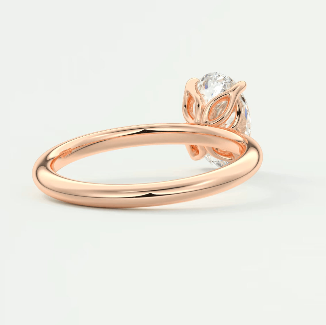 Rose gold owl engagement ring with a clear gemstone center and leaf details.