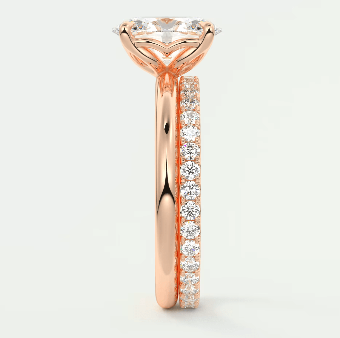 18-karat rose gold engagement ring with a round diamond center and pavé set diamonds on the band.