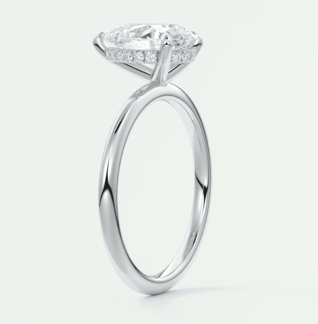 18k white gold engagement ring with a marquise-cut diamond and pave set diamonds on the band.