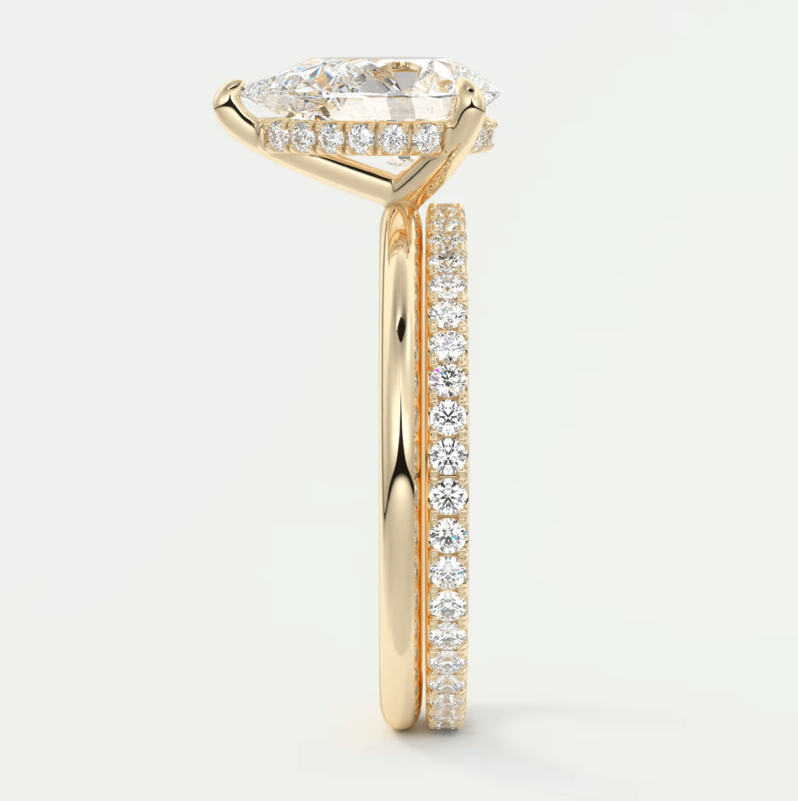18k yellow gold engagement ring with a pear-shaped diamond center and halo of smaller diamonds, featuring an elegant band design.
