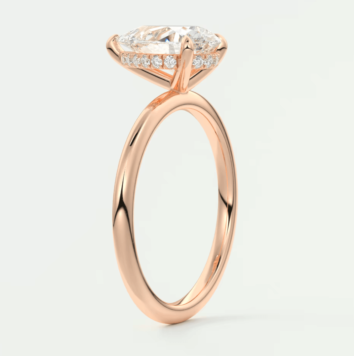 Rose gold engagement ring with a large, pear-shaped diamond and smaller diamonds along the band.