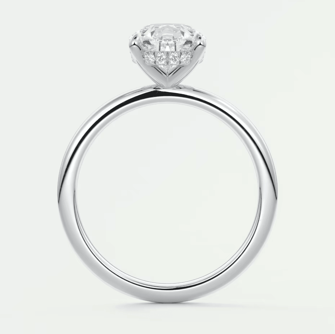 18-karat white gold engagement ring with a round diamond center stone and small diamonds set into the band.