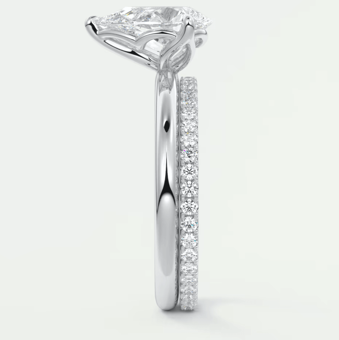 18-karat white gold diamond engagement ring with a cushion-cut center stone and pavé-set diamonds on the band.