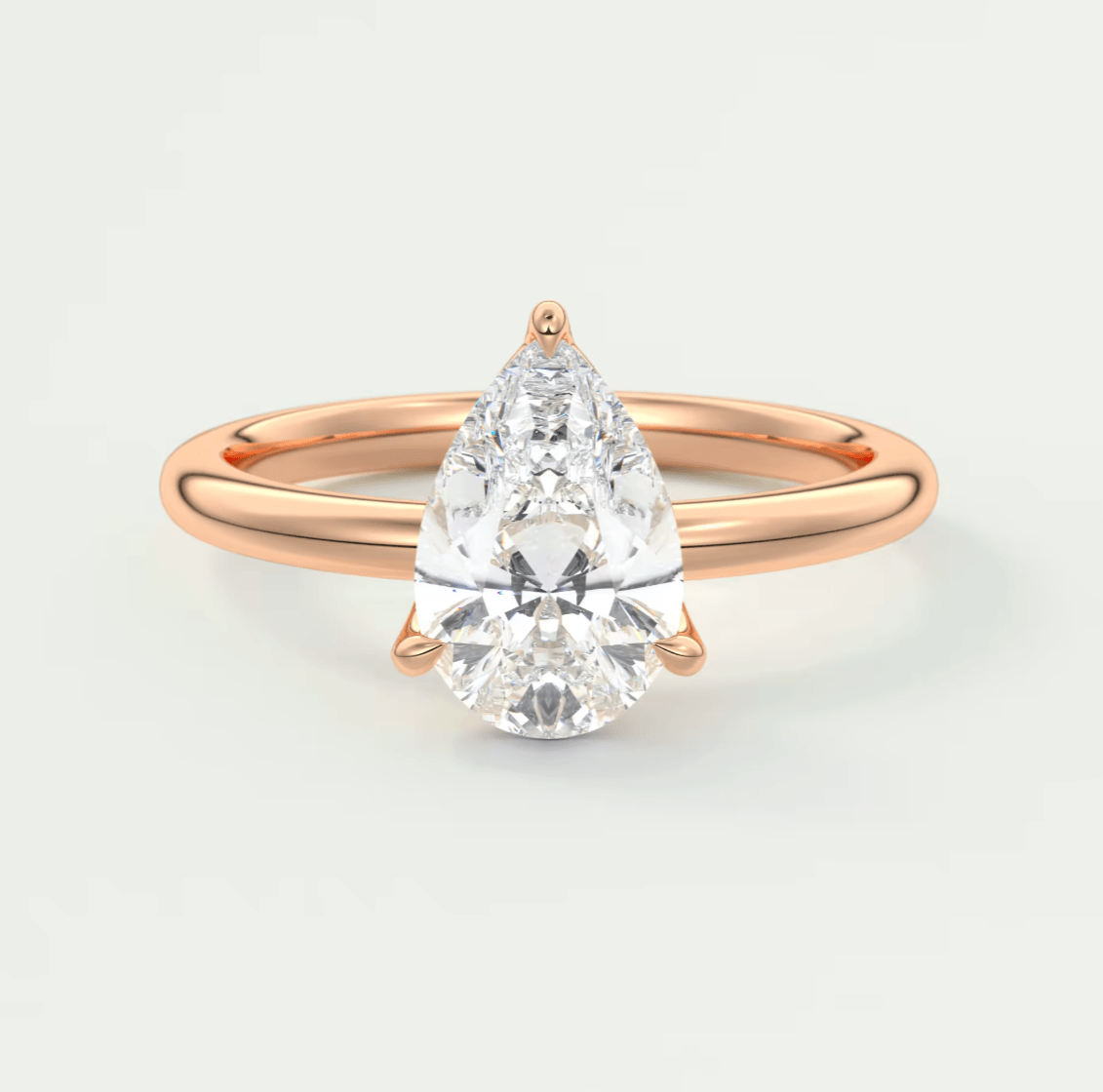 Rose gold pear-shaped diamond engagement ring with a solitaire design.